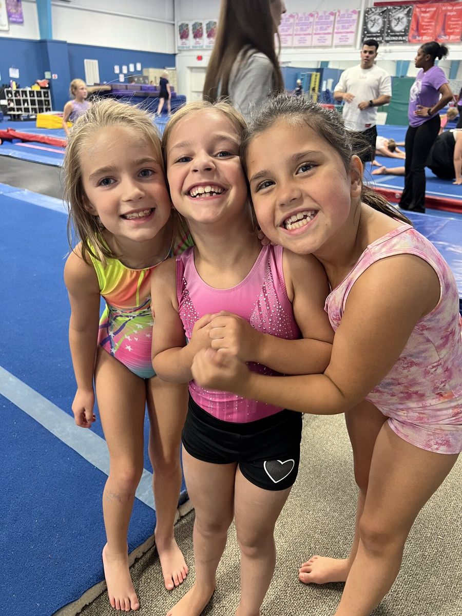 Three young gymnasts smiling together